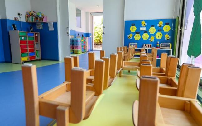 Mesas y sillas recogidas en un aula.