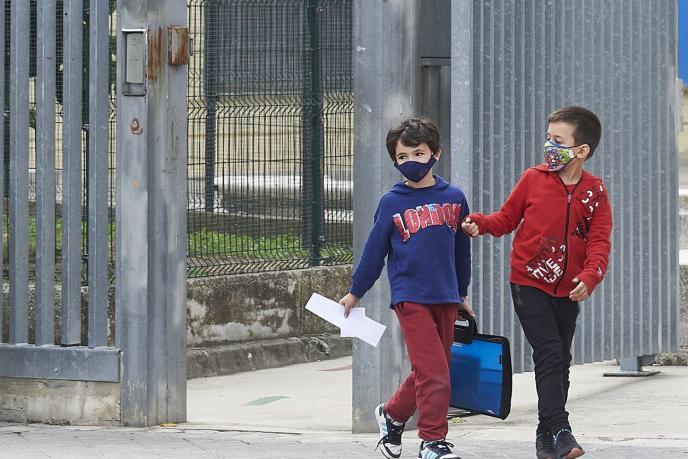 Dos niños con mascarilla en el exterior de sus centros