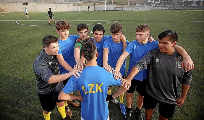 Varios jugadores del equipo de Segunda Juvenil del Lezkairu, arropando a uno de sus dos compañeros que no puede jugar.