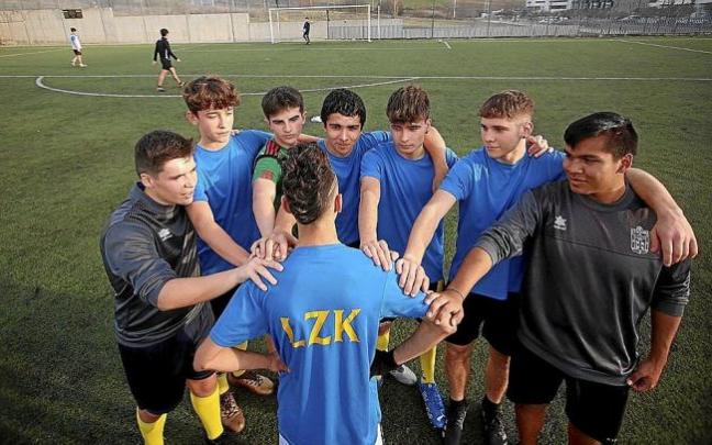 Varios jugadores del equipo de Segunda Juvenil del Lezkairu, arropando a uno de sus dos compañeros que no puede jugar.