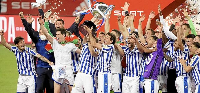 Illarramendi y Oyarzabal, al unísono, levantan la Copa en compañía del resto de la plantilla, en el estadio de La Cartuja.