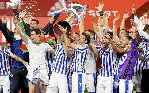 Illarramendi y Oyarzabal, al unísono, levantan la Copa en compañía del resto de la plantilla, en el estadio de La Cartuja.