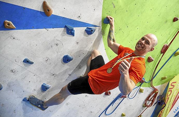 Eric Noya posa con su medalla en el muro de 15 metros.