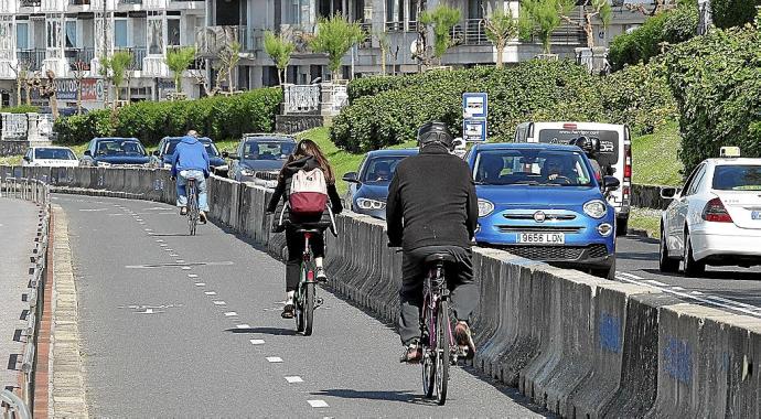 Ciclistas pasan por el bidegorri provisional, que se transformará para convertirse en definitivo.