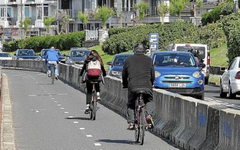 Ciclistas pasan por el bidegorri provisional, que se transformará para convertirse en definitivo.