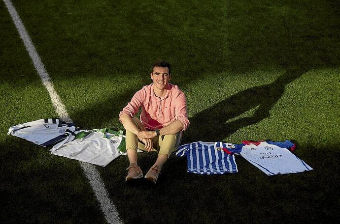 Javier Briñol posa en el césped de Mutilnova con las camisetas que ha vestido en su trayectoria.