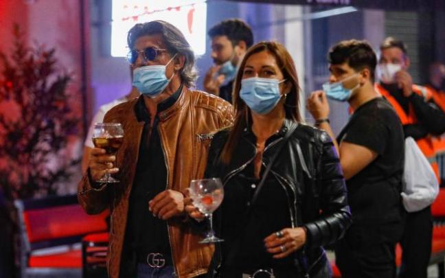 Una pareja pasea por una zona de ocio nocturno.