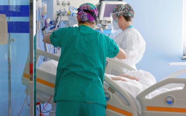 Dos sanitarias atienden a un paciente en la Unidad de Cuidados Intensivos del hospital de Cruces.