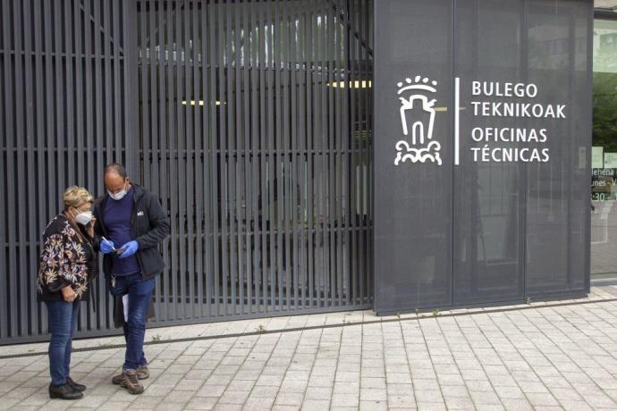 Dos personas en el acceso a las oficinas municipales de San Martín.