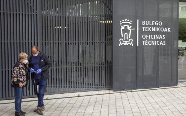 Dos personas en el acceso a las oficinas municipales de San Martín. Dos personas en el acceso a las oficinas municipales de San Martín.