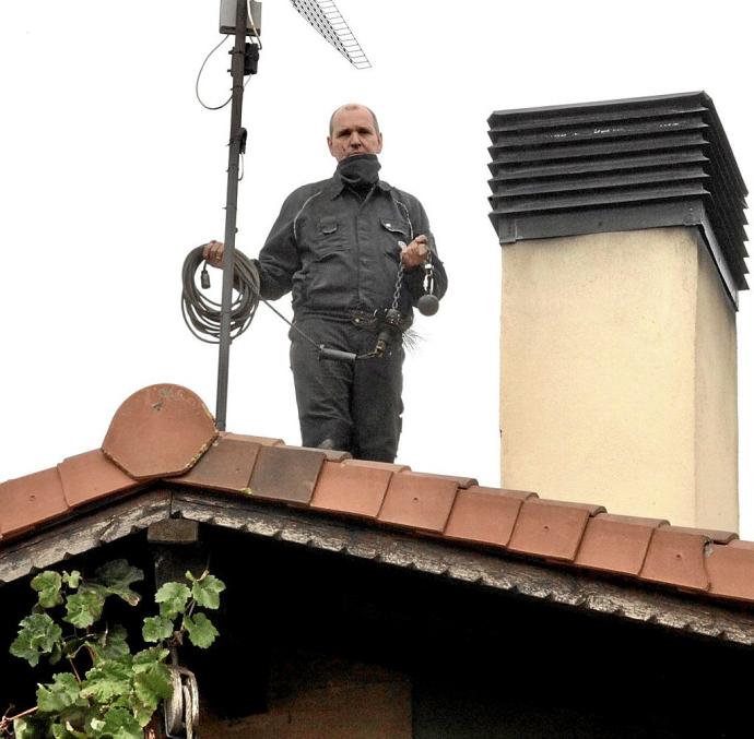 El deshollinador alemán Matthias Jörger trabajando en una casa en Corres en sus labores de deshollinador limpiando una chimenea. Foto: P.B.