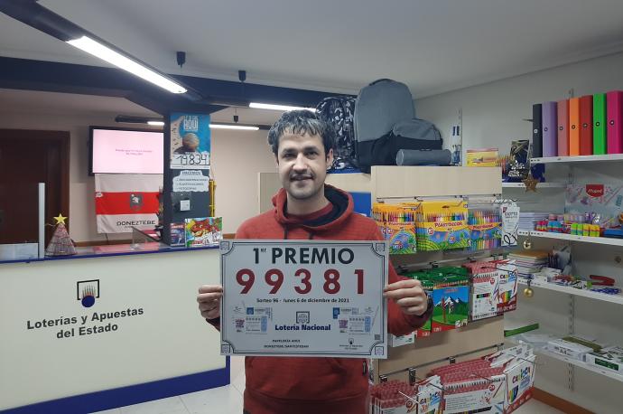 Odei Beltrán posa con el número premiado en la papelería y punto de venta de Lotería Anoi.