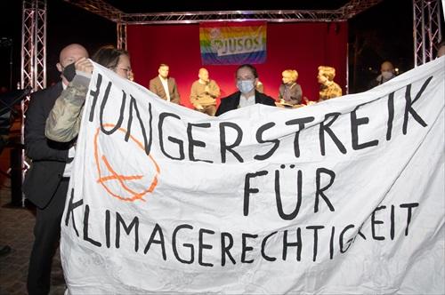 Activistas climáticos sostienen una pancarta que dice "Huelga de hambre por la justicia climática".