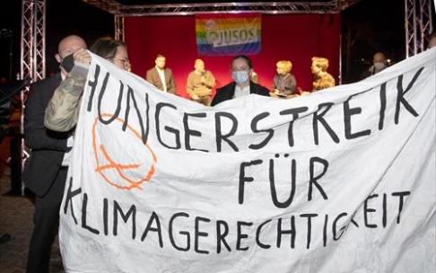 Activistas climáticos sostienen una pancarta que dice "Huelga de hambre por la justicia climática". Activistas climáticos sostienen una pancarta que dice "Huelga de hambre por la justicia climática".