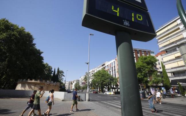 Unas personas caminan junto a un termómetro que marca 41 grados. Unas personas caminan junto a un termómetro que marca 41 grados.