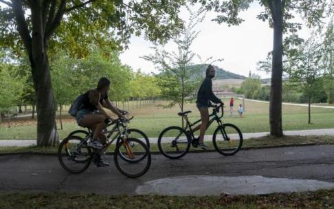 Jóvenes circulando en bicicleta por las campas de Olarizu
