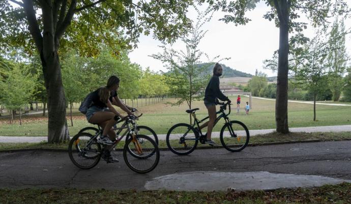 Jóvenes circulando en bicicleta por las campas de Olarizu