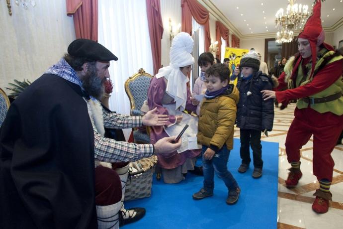 Olentzero y Mari Domingi saludan a unos niños y recogen sus cartas.