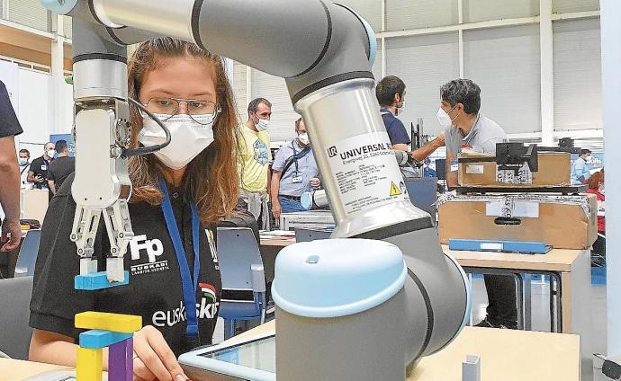 Una estudiante de FP, frente a un brazo robotizado en Ficoba.