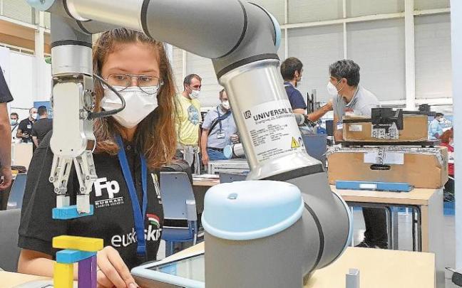 Una estudiante de FP, frente a un brazo robotizado en Ficoba.