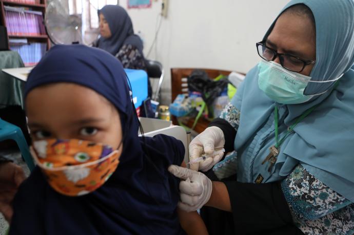 Una niña recibe una dosis de la vacuna en Indonesia.