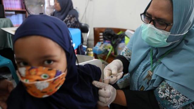 Una niña recibe una dosis de la vacuna en Indonesia.