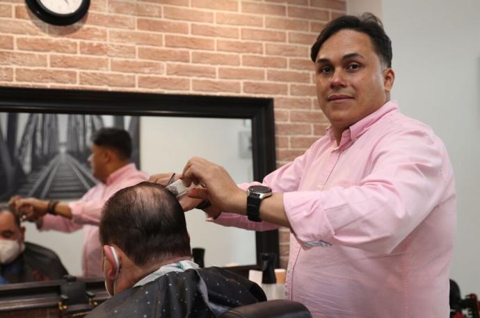 José Ramírez corta el pelo a un cliente en su barbería La Creación, situada en la calle Río Alzania de Azpilagaña.