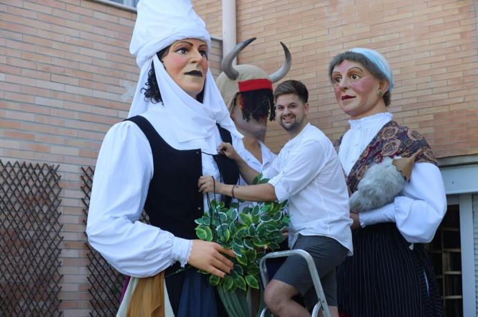 Fermín ajusta el corpiño de un nuevo gigante que ha vestido, la Sorgiña del akelarre que celebra Hernani por San Juan. Detrás, un adarra y una casera.