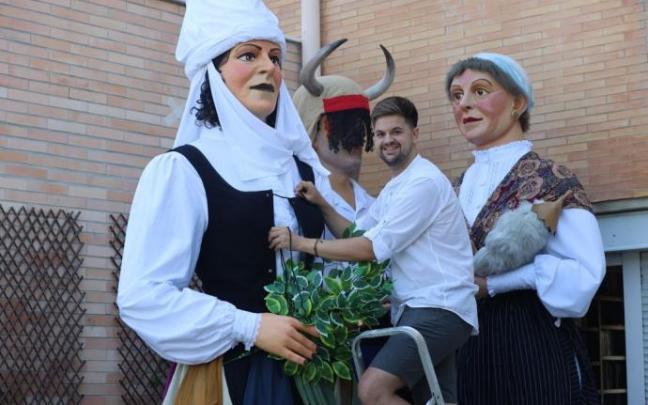 Fermín ajusta el corpiño de un nuevo gigante que ha vestido, la Sorgiña del akelarre que celebra Hernani por San Juan. Detrás, un adarra y una casera.