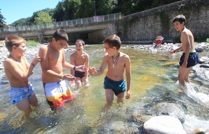Unos niños juegan en un río durante una ola de calor.
