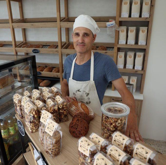 El panaderio Xabier Oroz posa en su panadería con diferentes productos.