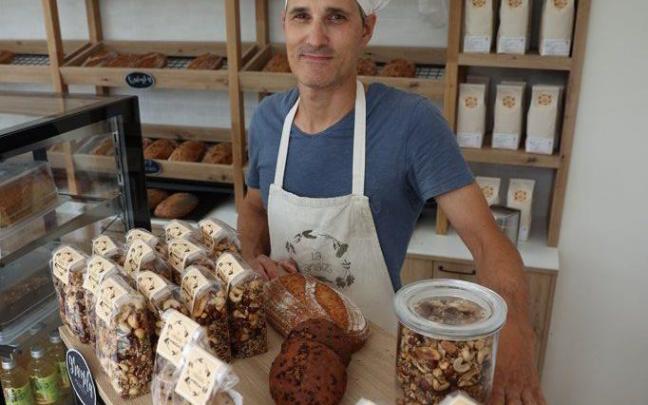 El panaderio Xabier Oroz posa en su panadería con diferentes productos.