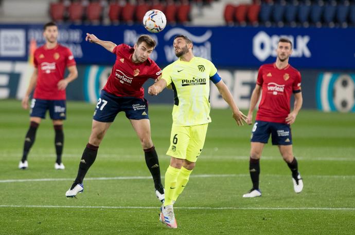 Duelo aéreo entre Moncayola y Koke durante un partido en El Sadar.