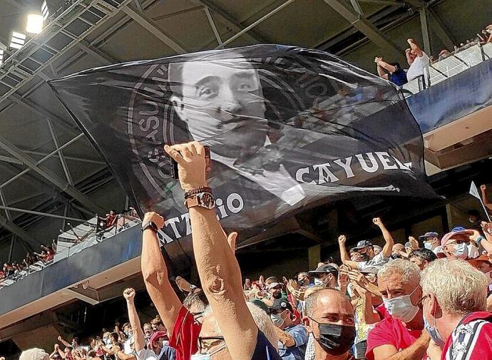 Una bandera con la imagen y el nombre de Natalio Cayuela, ondeando en El Sadar durante un partido de Osasuna de esta temporada. Foto: cedida