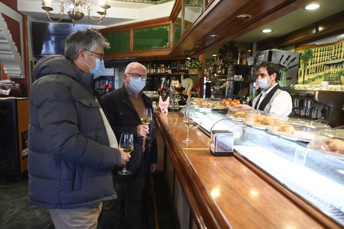 Dos hombres consumen en la barra del bar Víctor en la Plaza Nueva de Bilbao.