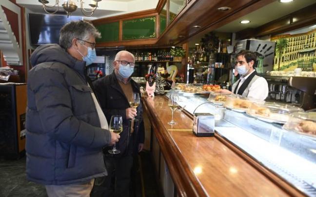 Dos hombres consumen en la barra del bar Víctor en la Plaza Nueva de Bilbao.