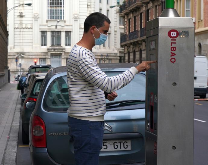 Un hombre saca la OTA en el centro de Bilbao. Los vecinos de La Peña, Ibarrekolanda y San Ignacio podrán solicitar la tarjeta desde el martes