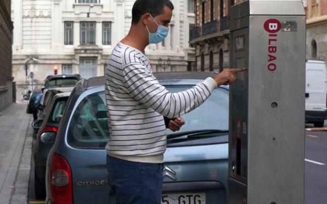 Un hombre saca la OTA en el centro de Bilbao. Los vecinos de La Peña, Ibarrekolanda y San Ignacio podrán solicitar la tarjeta desde el martes