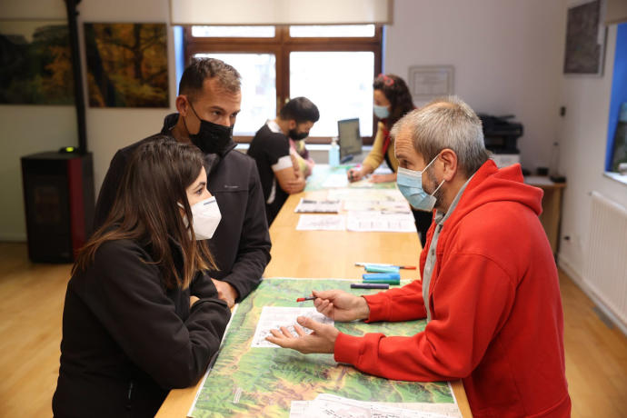 Gustavo Goiena da explicaciones a una pareja de turistas en la Oficina de Turismo de Otsagabia.