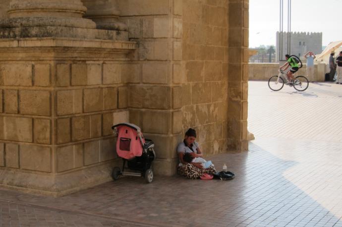 Una madre y su hija pequeña piden en una calle de España.