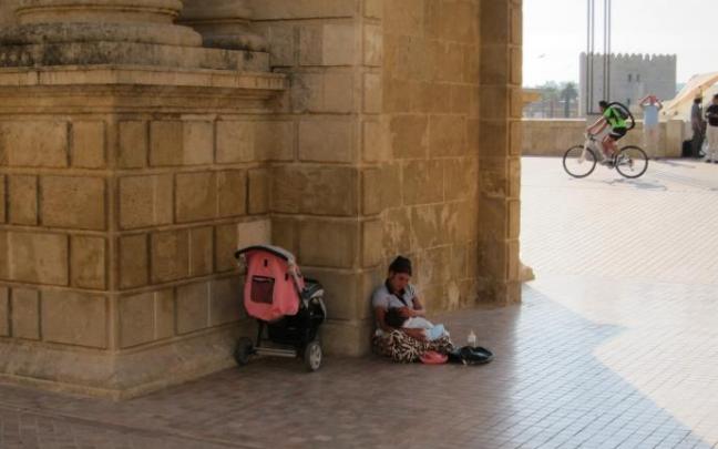 Una madre y su hija pequeña piden en una calle de España. Una madre y su hija pequeña piden en una calle de España.