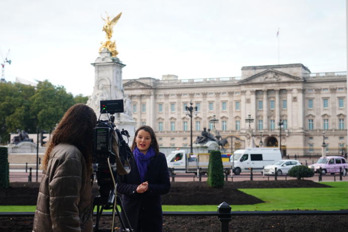 Una periodista frente al Palacio de Buckingham.