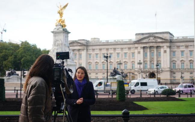Una periodista frente al Palacio de Buckingham.