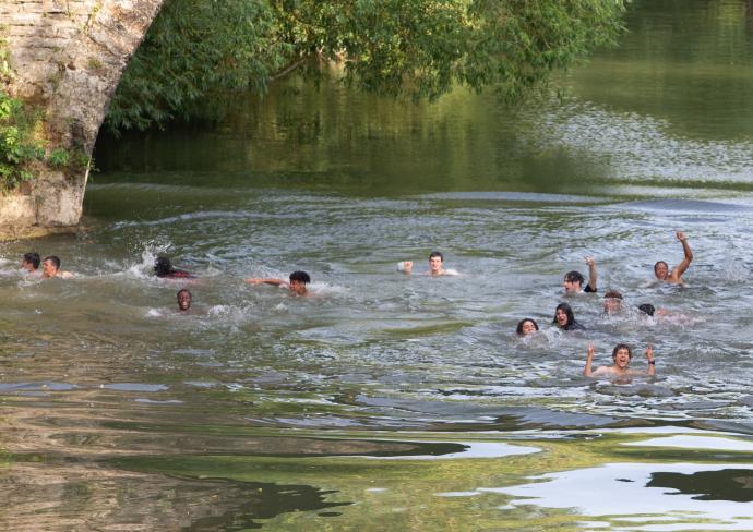 Jóvenes se bañan en el puente de la Magdalena.