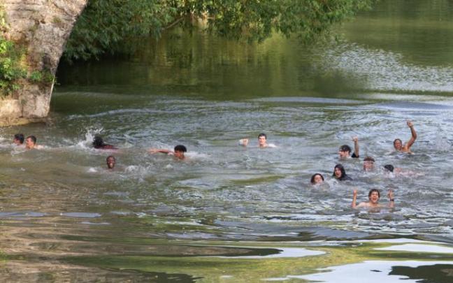 Jóvenes se bañan en el puente de la Magdalena.
