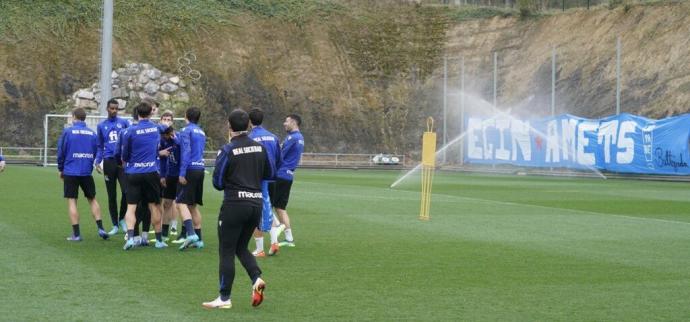 Los jugadores realistas bromean al inicio del entrenamiento con la pancarta de Bultzada al fondo.