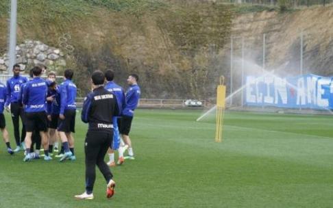 Los jugadores realistas bromean al inicio del entrenamiento con la pancarta de Bultzada al fondo.
