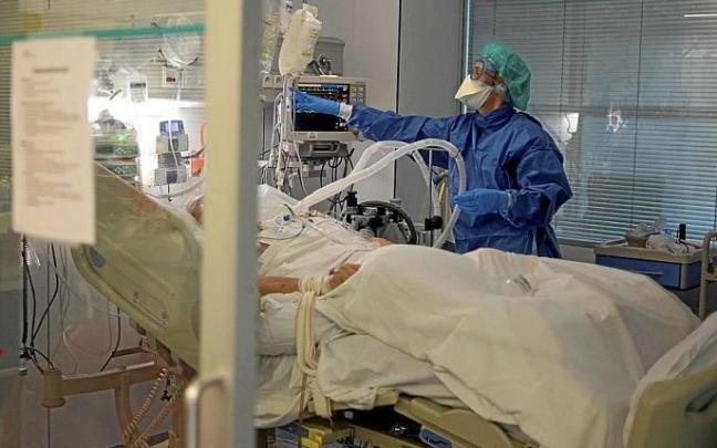 Un sanitario atiende a un paciente con COVID en la UCI de un hospital.