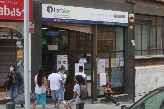 Varias personas aguardan en las inmediaciones de una oficina de Lanbide en Bilbao.