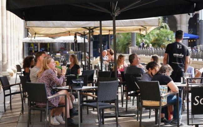 Unas personas toman una consumición en la Plaza Nueva de Bilbao